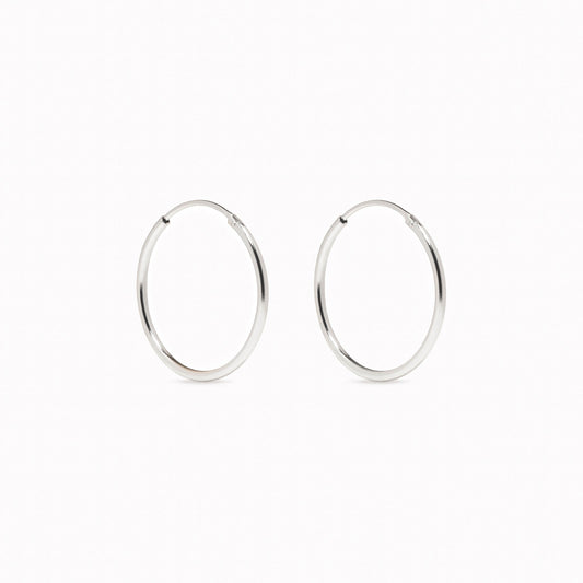 Close-up of White Gold Hoops 18mm - Sonia, elegant 14k white gold classic hoop earrings on a white background