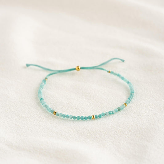 Amazonite Bracelet with delicate blue beads and gold vermeil accents laid flat on a light fabric background