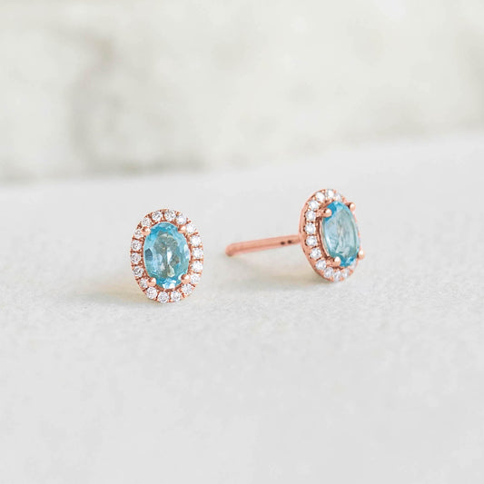 Swiss Blue Topaz Halo Stud Earrings Rose Gold - Marzia oval-cut blue topaz with diamond halo on soft gray background