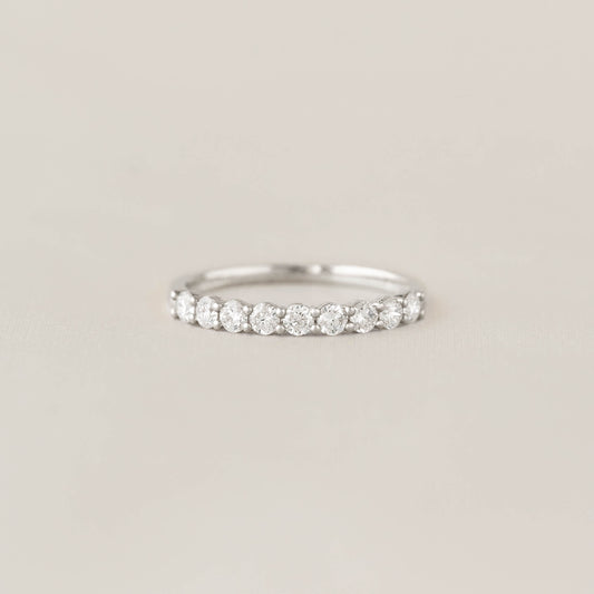 Elegant White Gold ring with a row of sparkling diamonds, set against a soft, neutral background. The design exudes simplicity and sophistication.