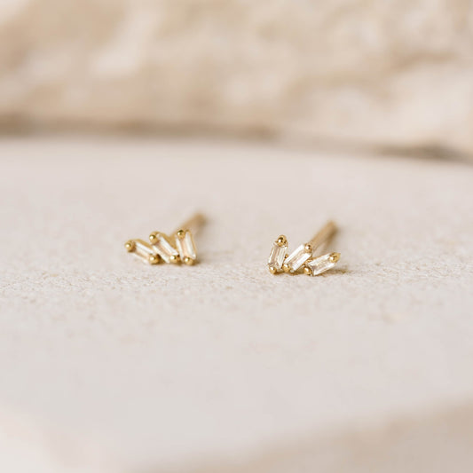 Close-up of Baguette Cluster Gemstone Stud Earrings - Lovise with gold vermeil and white topaz stones on a neutral background