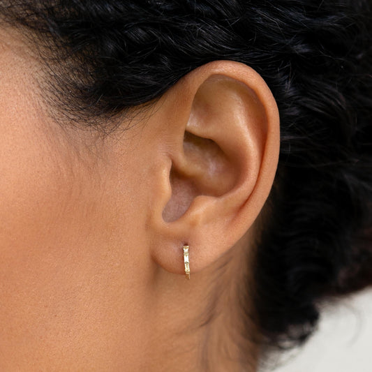 14k gold huggie earrings with white topaz stones in a baguette cut