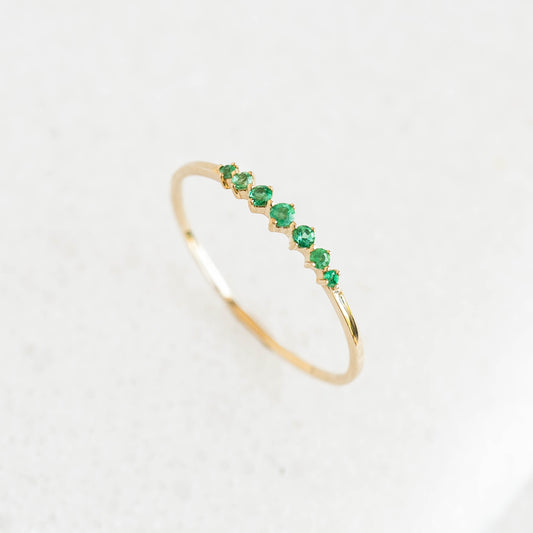 Graduated Emerald Ring 14k Gold - Mila with seven round emeralds in varying sizes on a white background