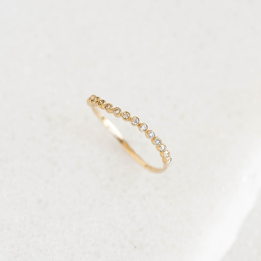 Diamond Wavy Ring 14k Gold - Amara with 16 bezel-set lab grown diamonds on a clean white surface close-up