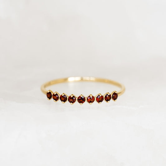 January Birthstone Ring 14k Gold - Garnet featuring nine small garnet gemstones set on a delicate gold band on white background