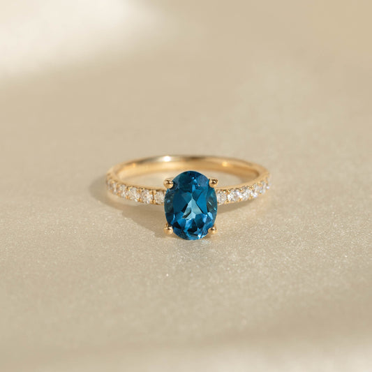 Oval London Blue Topaz and Diamond Ring 14k Gold - Minette with pavé diamonds on a light neutral background