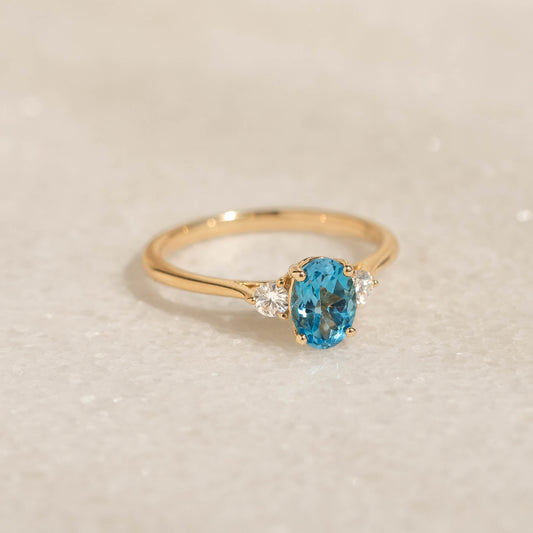 Swiss Blue Topaz and Diamond Ring 14k Gold - Kindra with oval-cut topaz and two accent diamonds on gold band