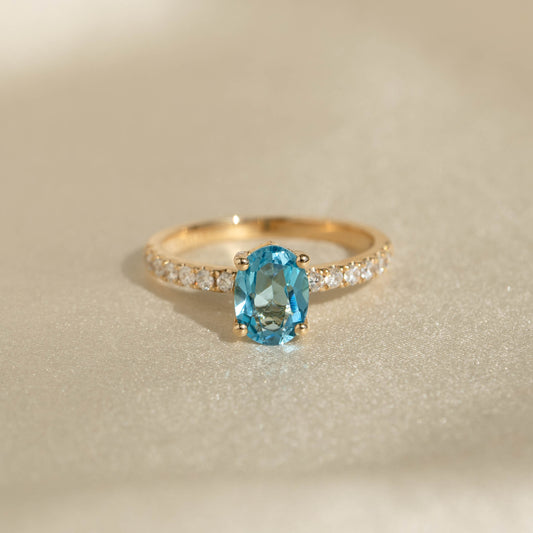 Close-up of Oval Swiss Blue Topaz and Diamond Ring 14k Gold - Minette showcasing a vibrant blue topaz and pavé diamonds on a gold band