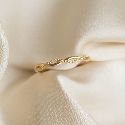 Diamond Twist Ring 14k Gold - Anais with intertwining bands, pave set diamonds and smooth gold finish on cream fabric background
