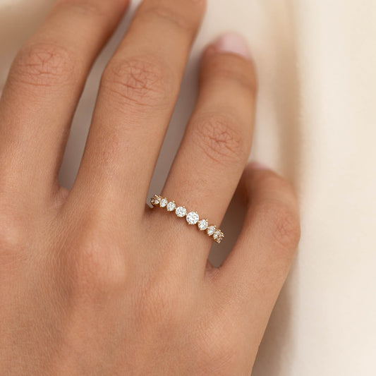 Close-up of hand wearing Graduated Diamond Ring 14k Gold - Giselle with 11 round diamonds on a gold band