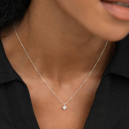 Close-up of a woman wearing the Flower Diamond Pendant Necklace White Gold - Fiorella with a black shirt background