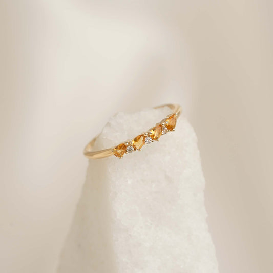 Close-up of November Birthstone Pear Ring 14k Gold - Citrine and Diamond on white textured stone background