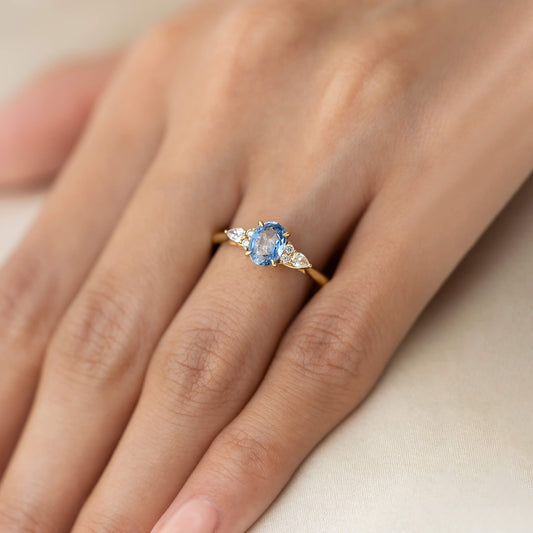 A close-up photograph shows the delicate Yellow Gold ring being worn on a person's ring finger, providing a detailed view of its scale and design.