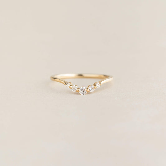 Close-up of the Graduated Diamond V Ring 14k Gold - Liora with five diamonds on a delicate gold band on a neutral background