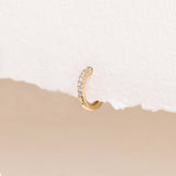 Close-up of 14k Yellow Gold Diamond Huggie Earring - Susanna (Single) with 9 sparkling lab grown diamonds on white background