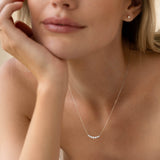 Close-up of a woman wearing the Graduated Diamond Necklace White Gold - Caterina with seven diamonds on a delicate chain