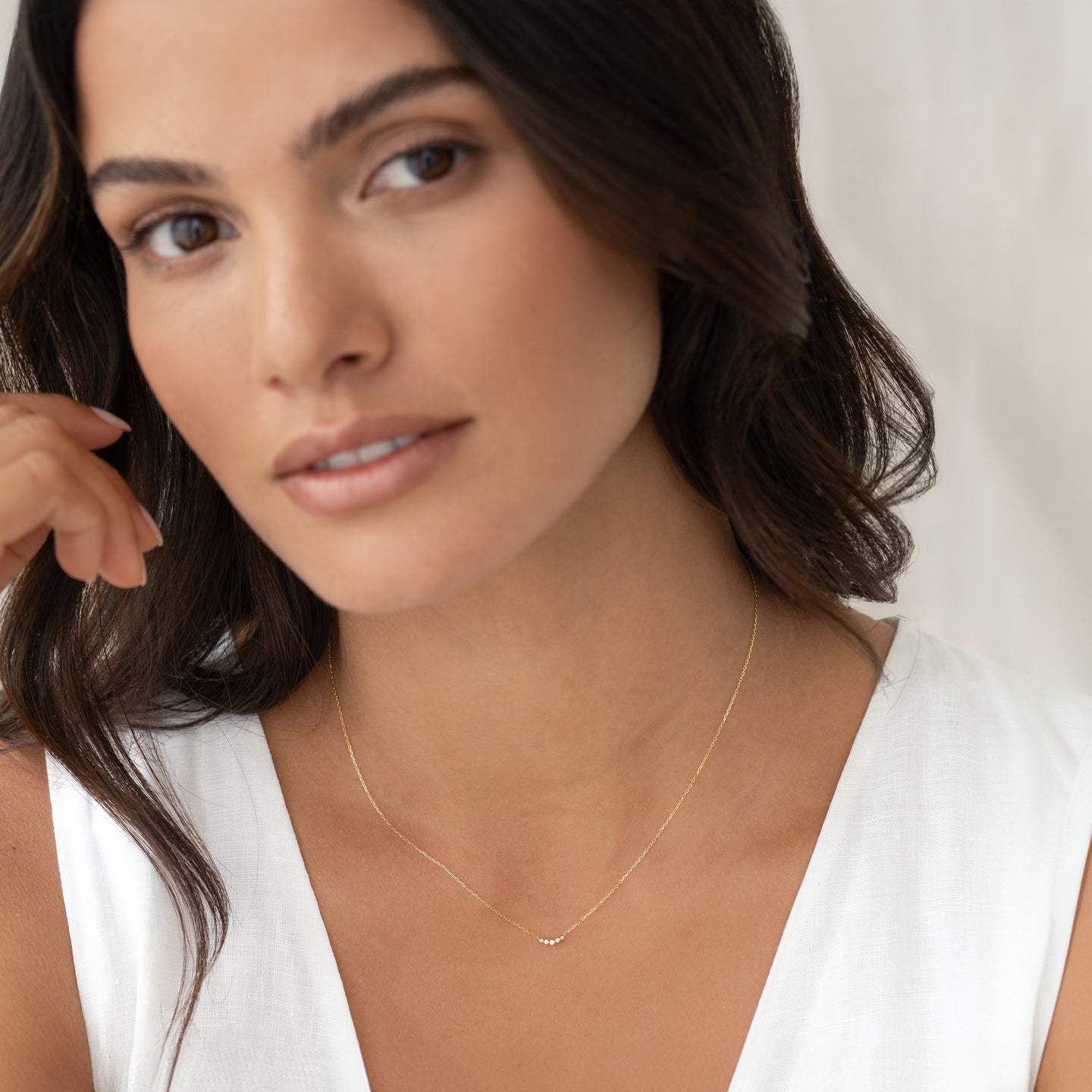 Close-up of woman wearing Diamond Curved Bar Necklace 14k Gold - Jemma with five tiny diamonds on a delicate chain
