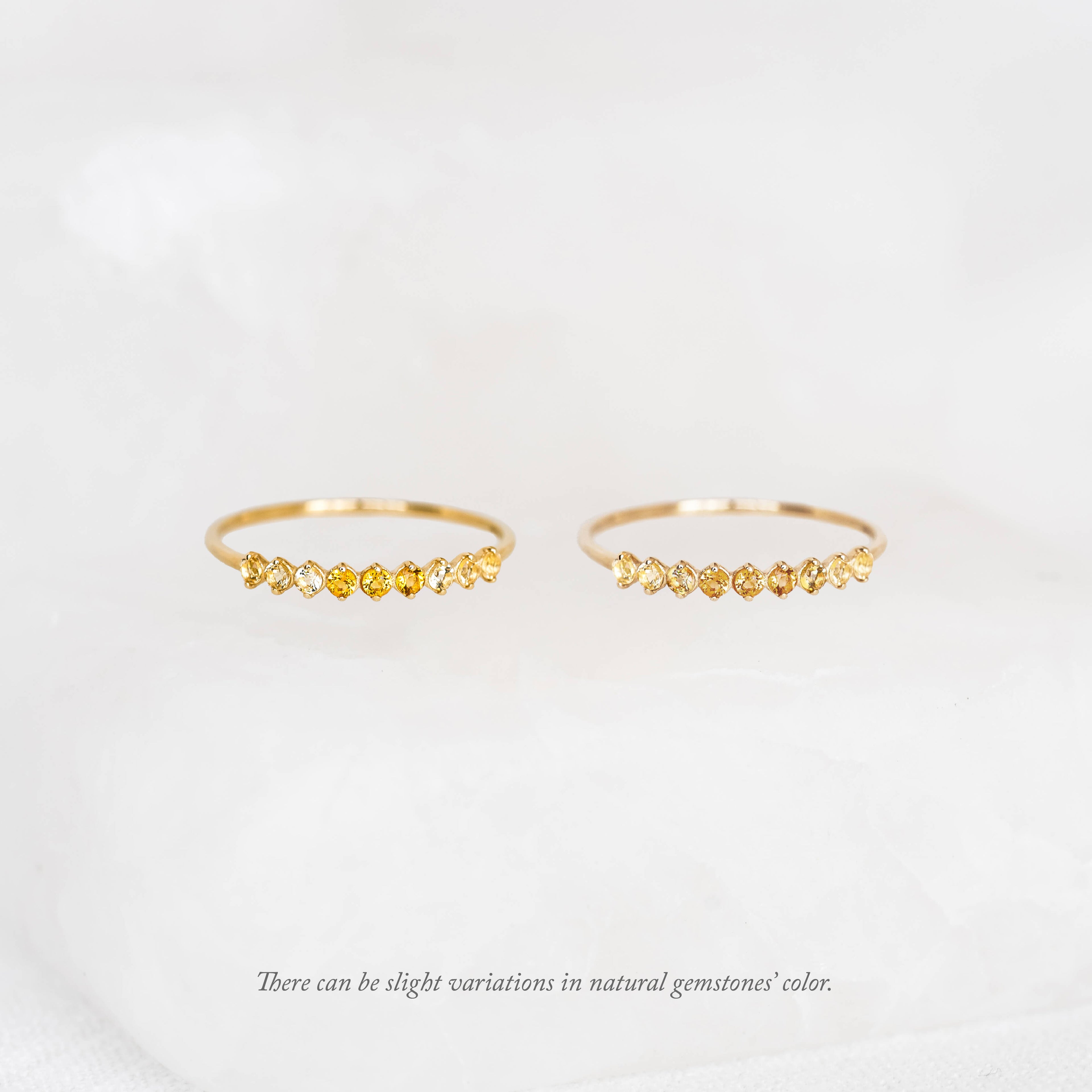 Two thin gold rings displayed side by side, each featuring a curved row of small round November Birthstone Ring across the top, set against a soft white background.
