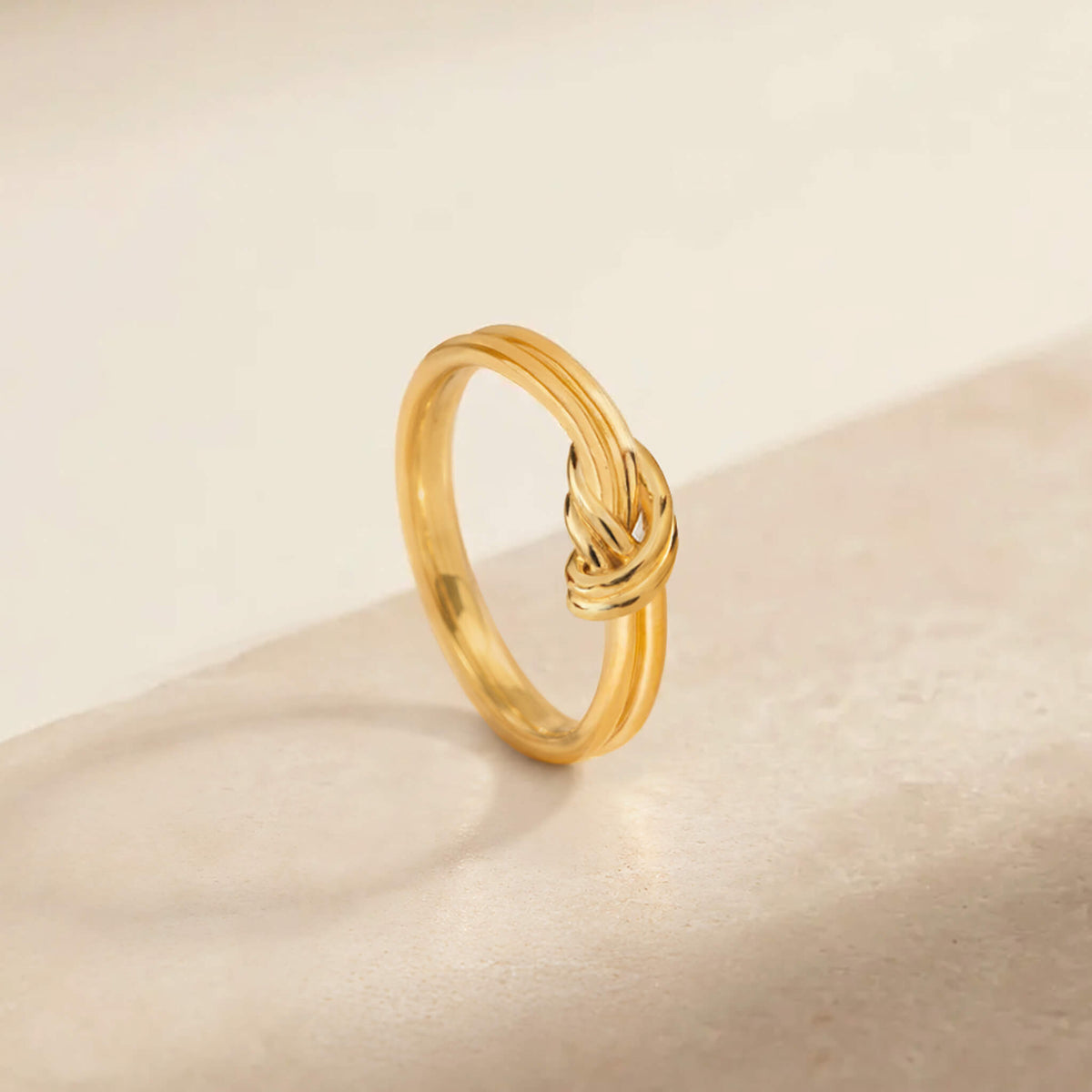 Delicate Gold knot ring displayed against a neutral background.