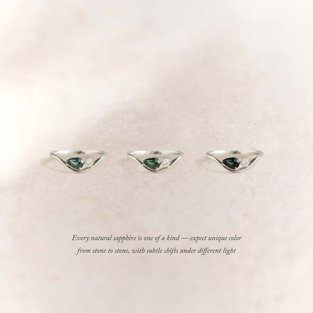 Three White Gold rings arranged horizontally on a soft beige background, each featuring a pear-shaped green sapphire paired with small white accent stones.