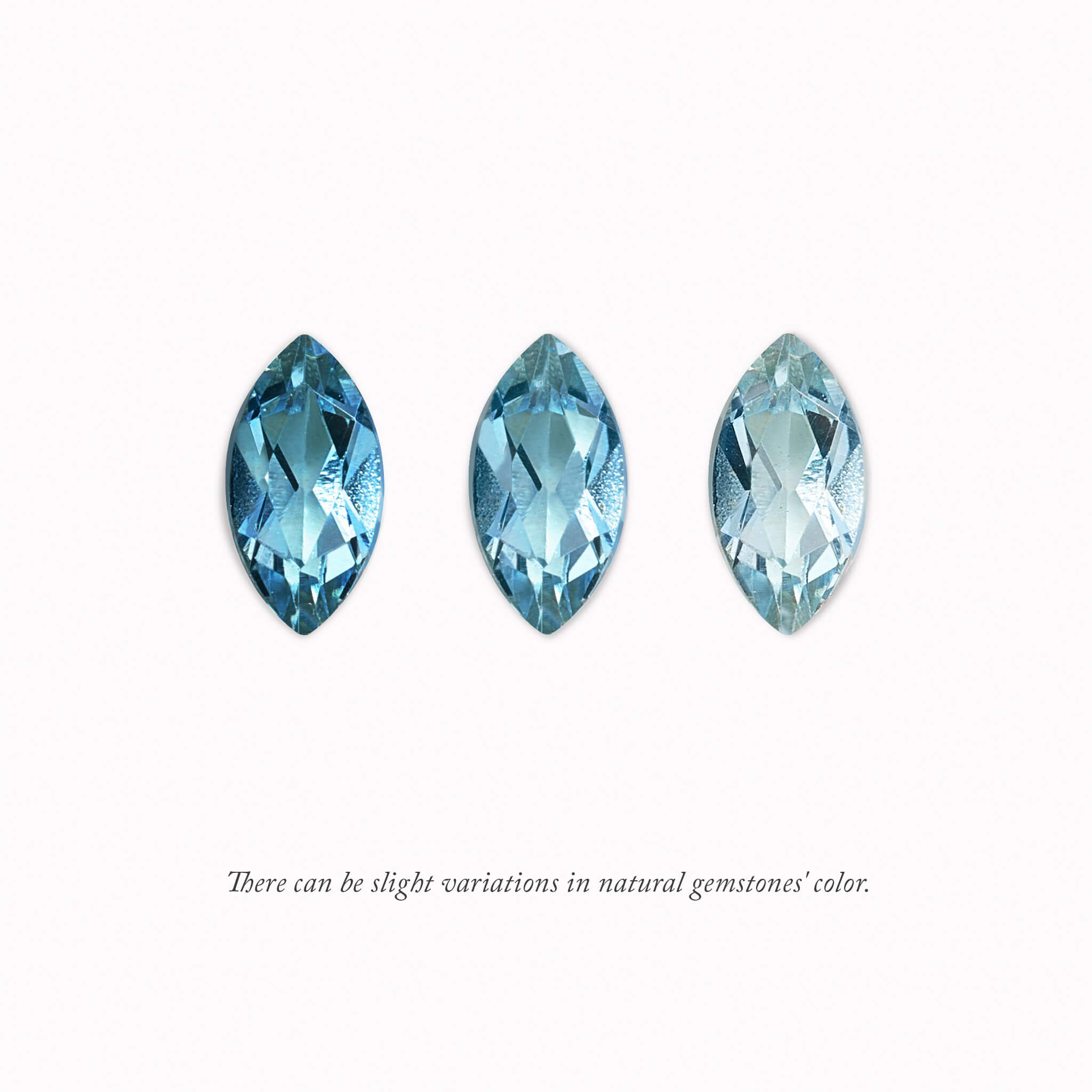 Three March Birthstone Charm in Swiss blue gemstones are arranged in a row on a white background. Each stone slightly varies in hue and brightness, demonstrating natural color variation