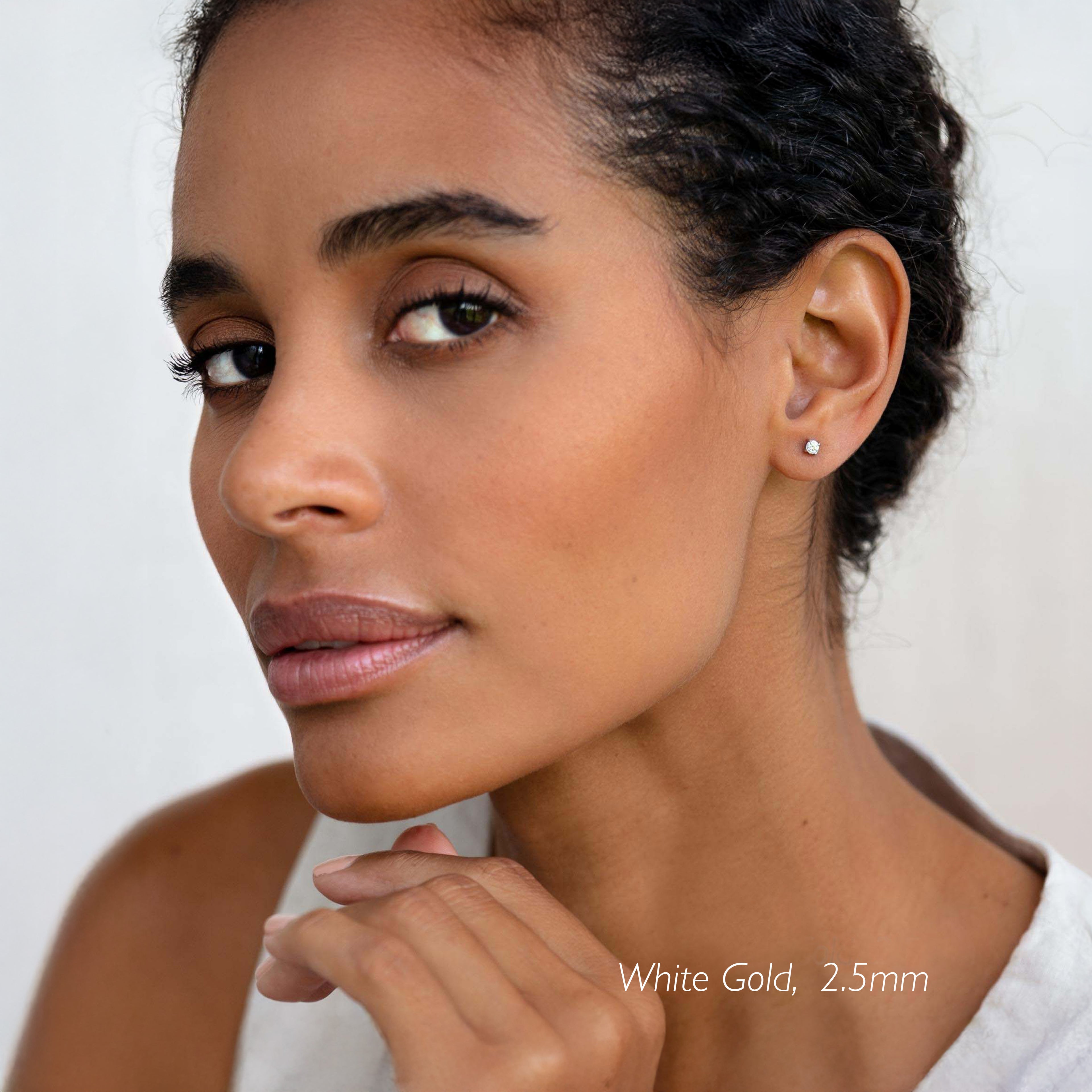 Close-up of woman wearing 14k White Gold Diamond Stud Earrings 2.5mm - Aria with natural makeup and neutral background