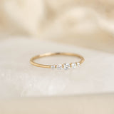 Close-up of Graduated Diamond Ring 14k Gold - Dahlia featuring five varying sized diamonds on a thin gold band