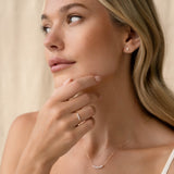Close-up of a woman wearing the Graduated Diamond Ring 14k Gold - Dahlia on her hand with neutral background