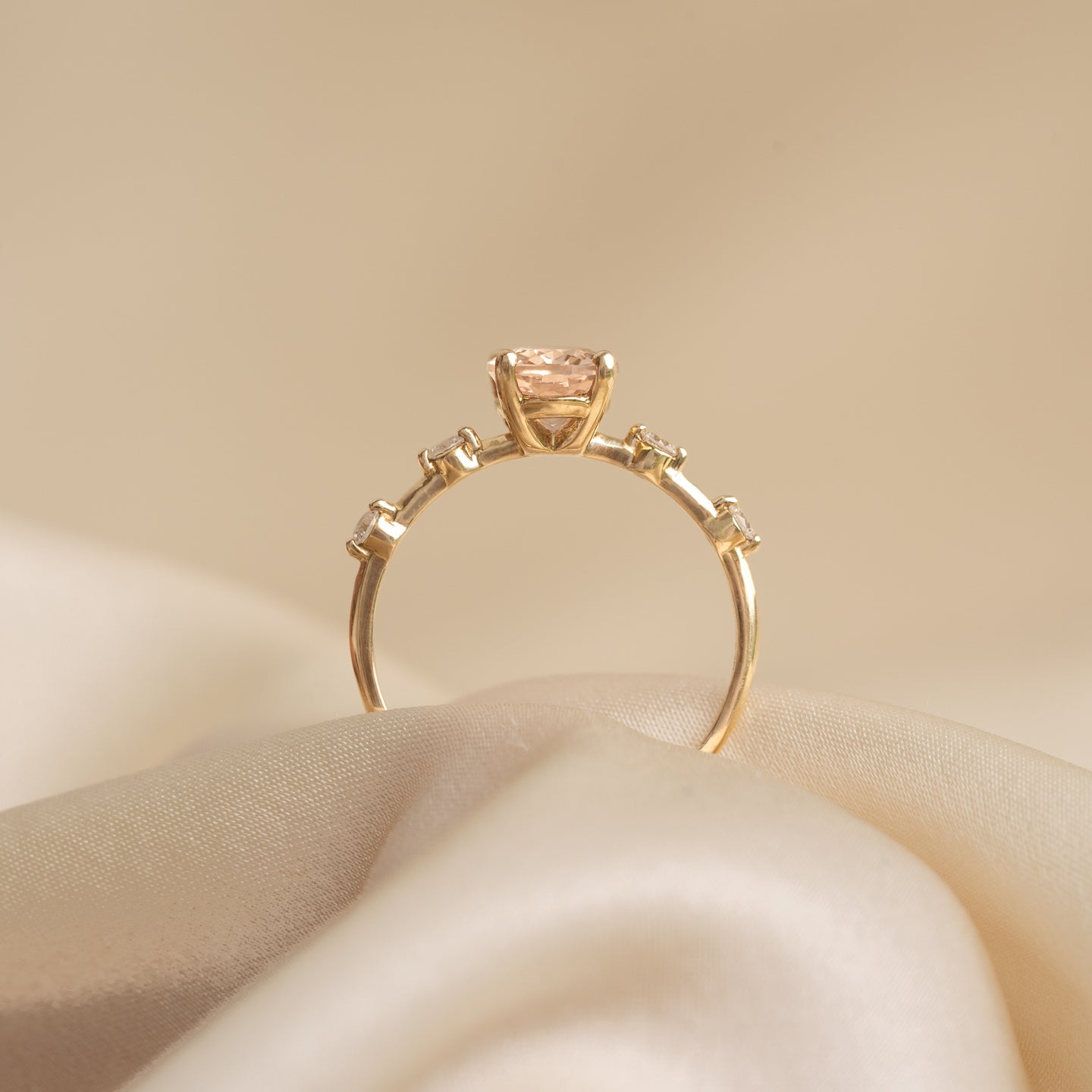 Oval Morganite and Diamond Ring 14k Gold - Demetria with oval morganite and small diamonds on a soft beige fabric background