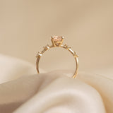 Oval Morganite and Diamond Ring 14k Gold - Demetria with oval morganite and small diamonds on a soft beige fabric background