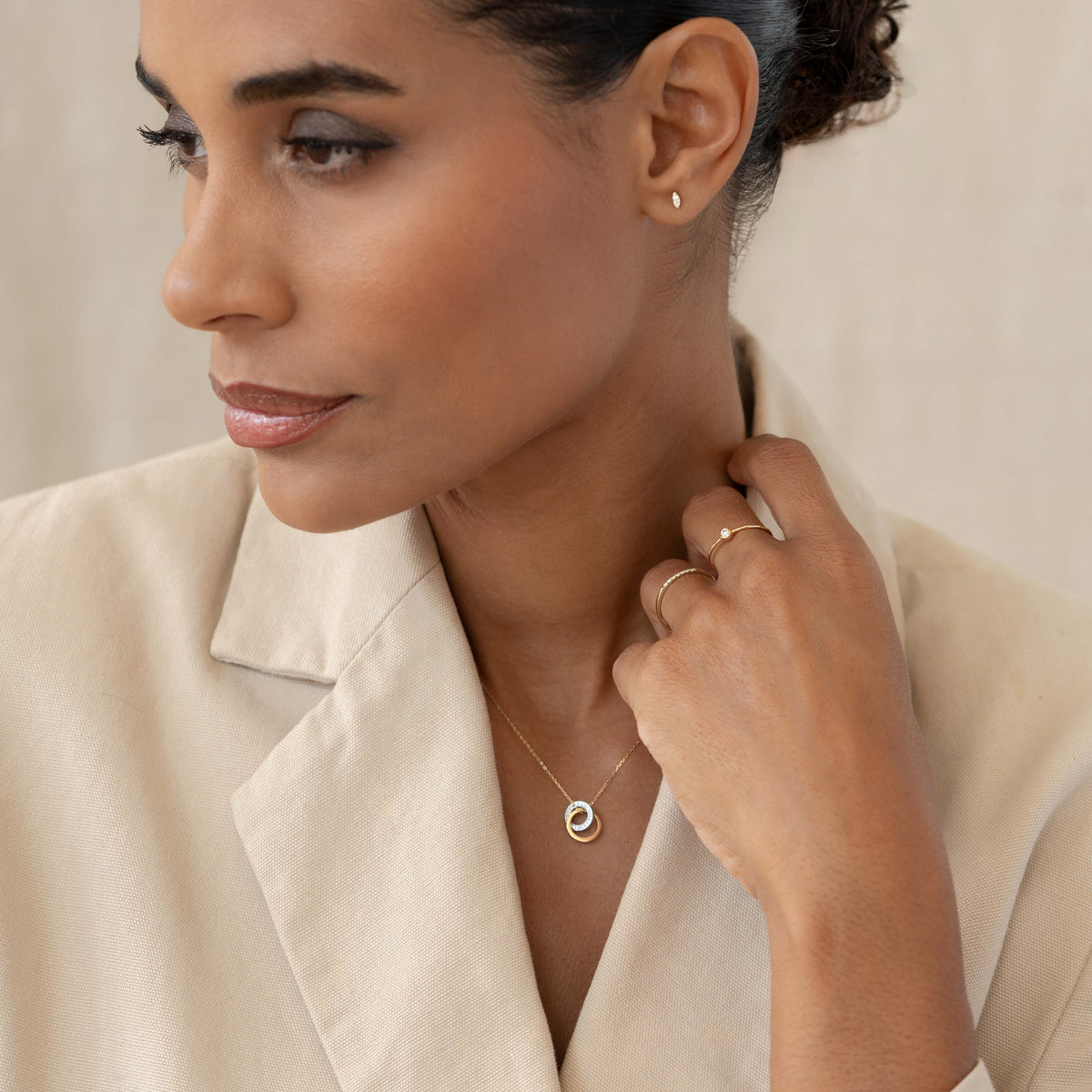 Woman wearing the Diamond Double Circle Necklace 14k Gold - Diana with matching gold rings and neutral blazer