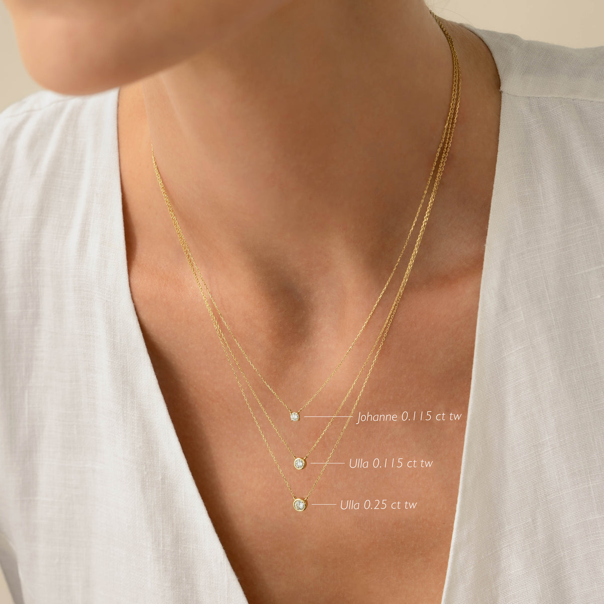 Close-up of a woman wearing the Bezel Set Lab Grown Diamond Necklace 14k Gold - Ulla layered with two other gold necklaces
