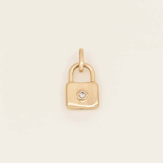 Yellow Gold padlock-shaped charm with a loop at the top and an engraved cursive letter “A” on the front, displayed against a light neutral background.