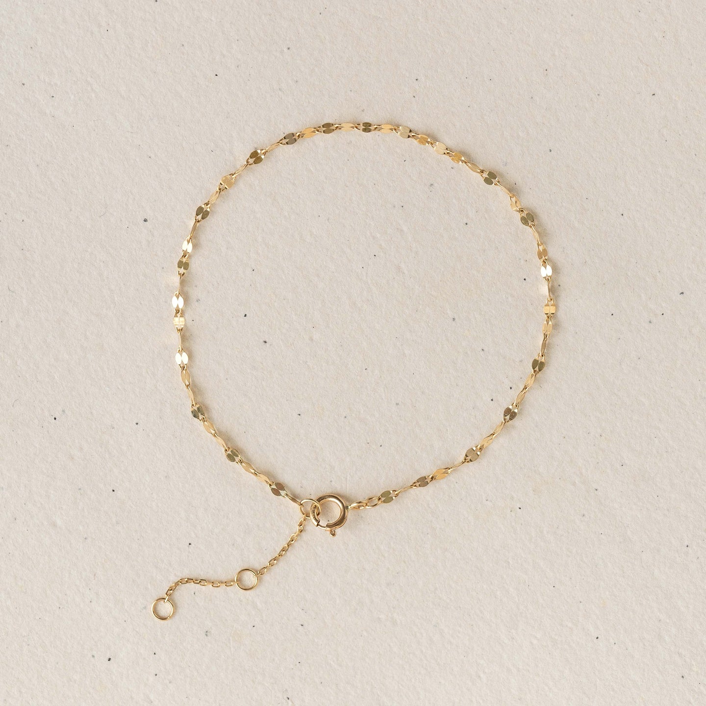 Petal Chain Bracelet 14k Gold - Florence with delicate petal-shaped links on a light beige background