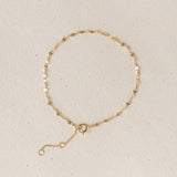 Petal Chain Bracelet 14k Gold - Florence with delicate petal-shaped links on a light beige background