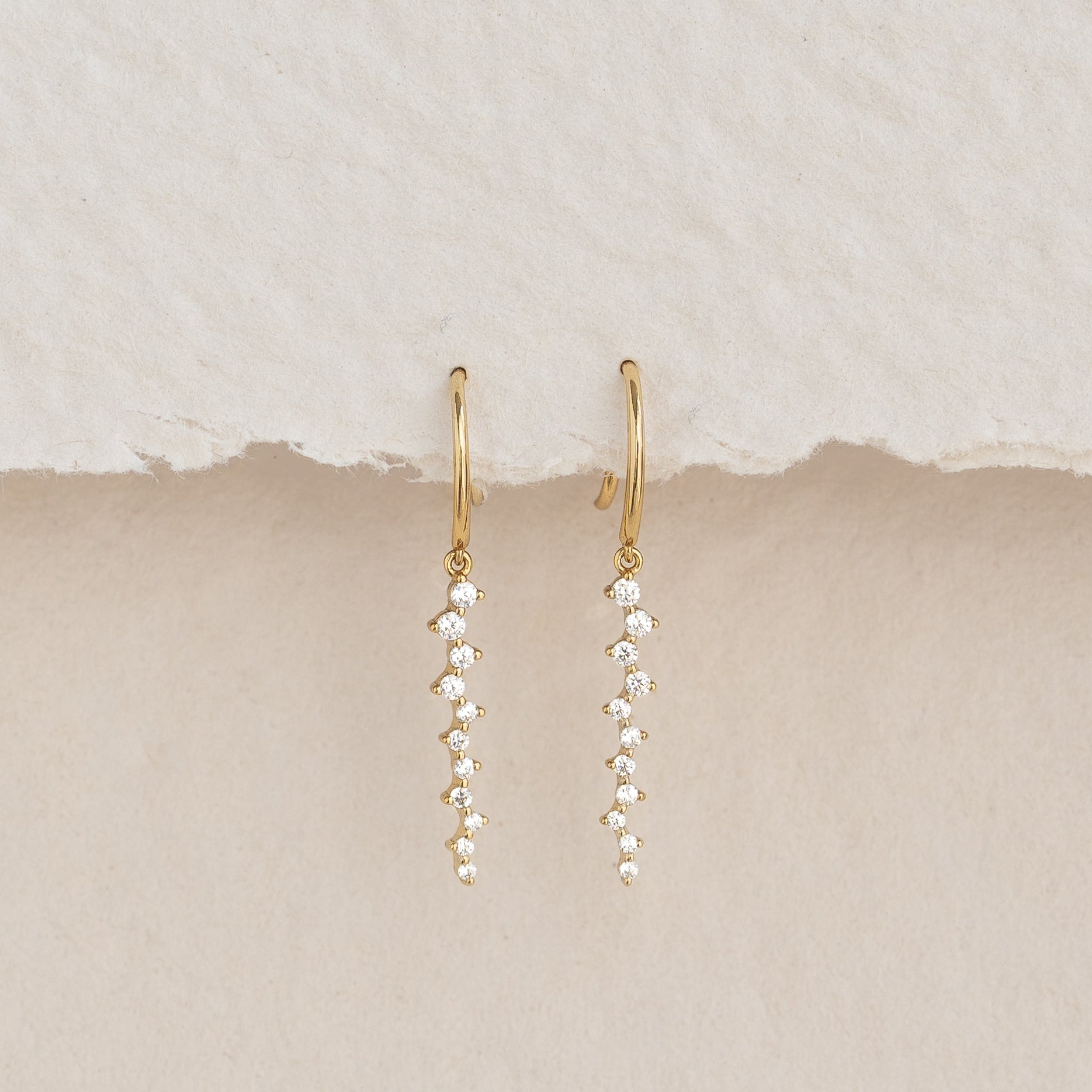 Gemstone Drop Earrings - Tamara featuring 22 cubic zirconia stones set in gold vermeil on a neutral textured background