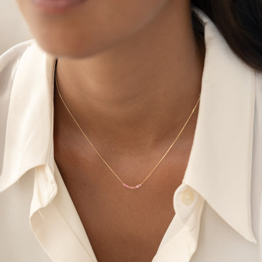 Close-up of a woman wearing the July Birthstone Necklace 14k Gold - Ombre Pink Tourmaline with a white blouse