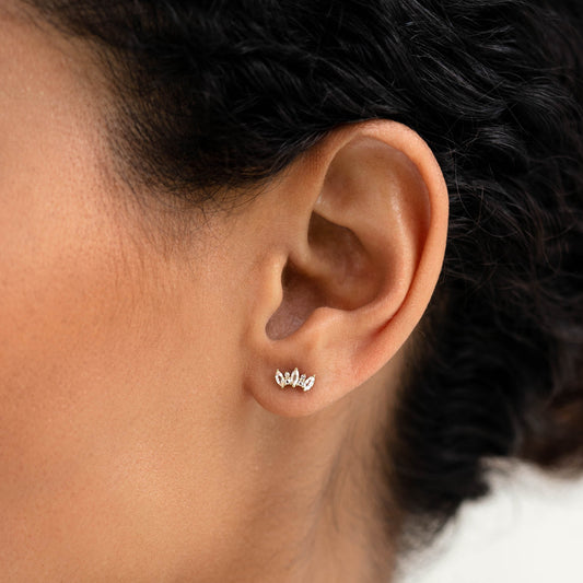 Close-up of a woman wearing Marquise Cluster Gemstone Stud Earrings - Lykke on her left ear against a white background