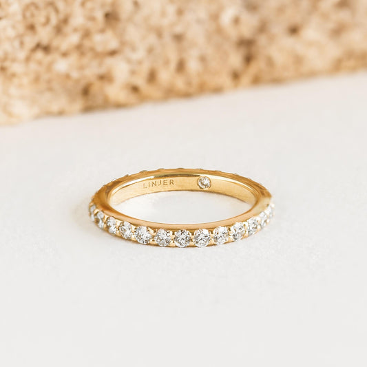 Diamond Eternity Ring 14k Gold - Illaria with continuous lab grown diamonds set on polished yellow gold band on neutral background
