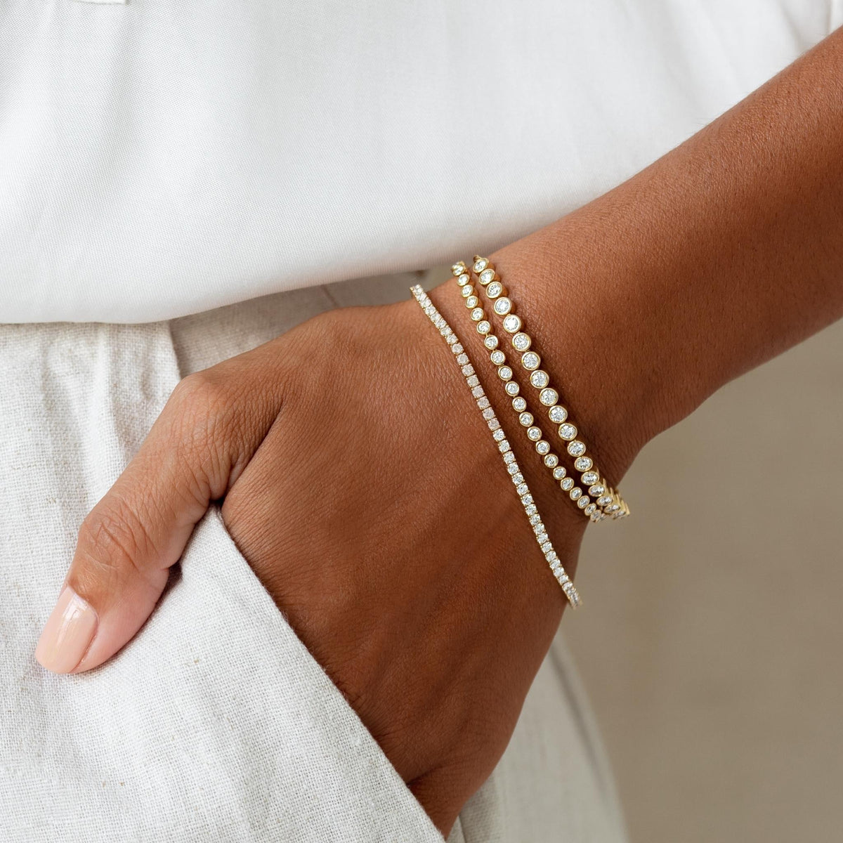 Stack of three lab grown diamond tennis bracelets on model