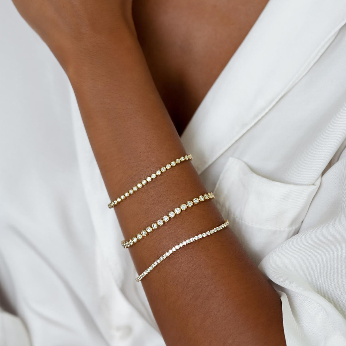 Three 14k solid gold brilliant cut diamond tennis bracelets on model