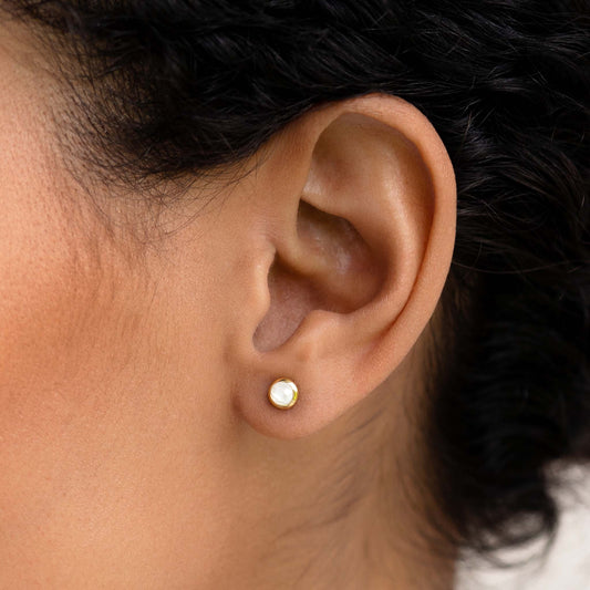 Dainty moonstone stud earrings on model
