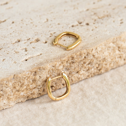 Square Huggie Earrings - Amelia in gold vermeil displayed on textured natural stone background