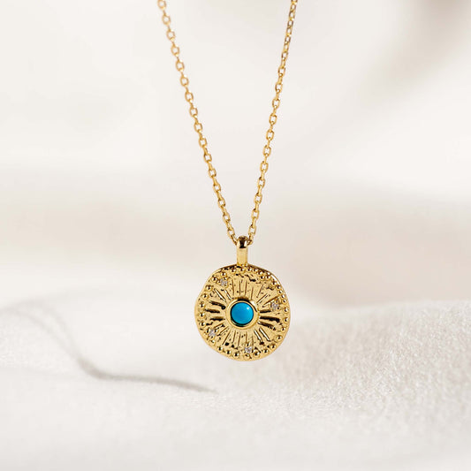 Gold Coin Necklace - Odina with organic gold coin pendant and turquoise stone on delicate gold chain against soft background