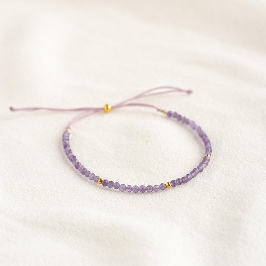 Delicate Amethyst Bracelet with small amethyst beads and gold vermeil accents on adjustable cord on a soft background