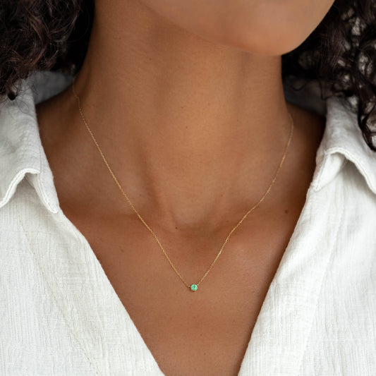 Close-up of woman wearing Emerald Pendant Necklace 14k Gold - Amalie with white textured shirt background