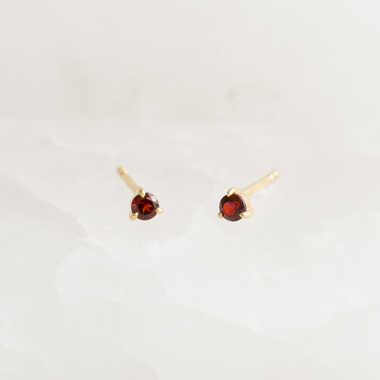 January Birthstone Stud Earrings 14k Gold - Garnet with round garnet gemstones in three-prong settings on a white background