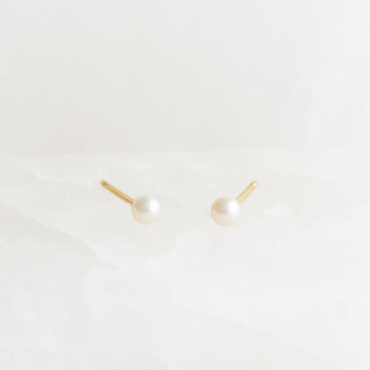 June Birthstone Stud Earrings 14k Gold - Pearl with delicate round pearls set in yellow gold three-prong settings on white background