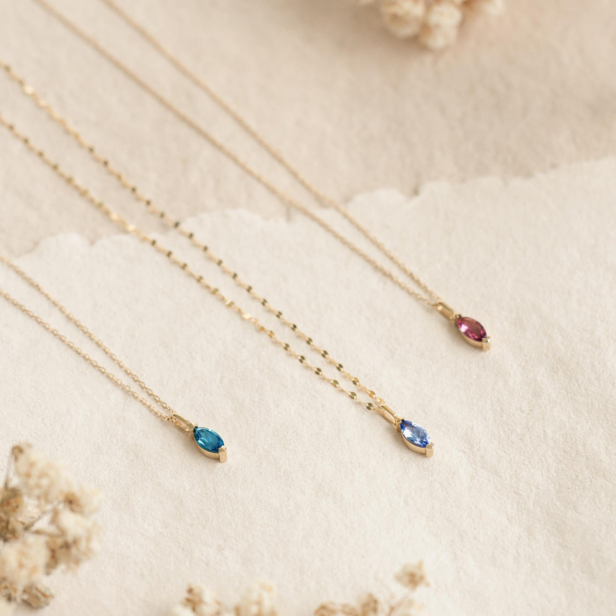 July Birthstone Pendant 14k Gold - Pink Tourmaline with marquise-cut stones on delicate gold chains displayed on a neutral background