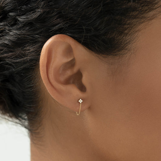 Close-up of an ear wearing Diamond Chain Earrings 14k Gold - Alva with delicate chain and star-shaped diamonds